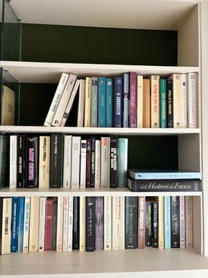 a book shelf with many books on it in a room