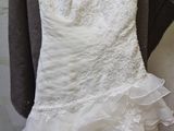 a wedding dress hanging on a mannequin on a mannequin stand