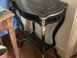 une petite table avec un plateau noir et une chaise à côté