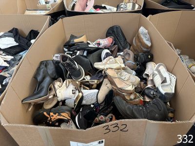 plusieurs paires de chaussures dans une boîte posée sur le sol