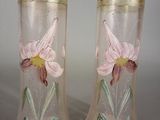 deux vases avec des fleurs peintes dessus, posés sur une table