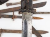 many different types of knives displayed on the wall