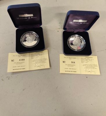 two silver coins are in a blue box on a table