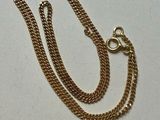 Collier à chaîne en plaqué or avec un fermoir et un fermoir sur fond blanc