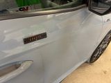 a white car with a sticker on the side of it ' s door