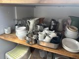 many dishes and cups on the shelves in the kitchen