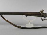 a rifle with a wooden barrel on a stand on a white background