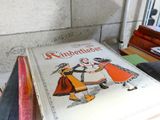 un livre posé sur une table, à côté d'une pile de livres