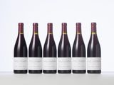 six bottles of red wine lined up in a row