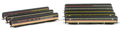 several model trains are lined up in a row on a white surface