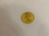 a gold coin sitting on a white surface