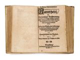 an old book is open on a white surface