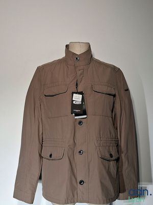 une veste marron sur un mannequin dans une pièce blanche