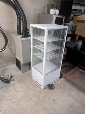 a white refrigerator sitting next to a bike in a garage