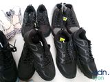 several pairs of black shoes are lined up on a white surface
