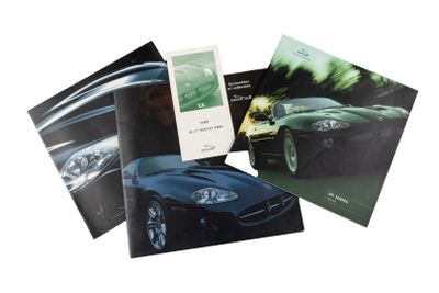trois livres posés sur une surface blanche, avec une voiture de sport noire en arrière-plan