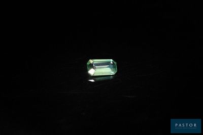 une tourmaline verte posée sur un fond noir