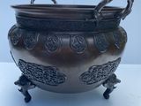 un pot antique en bronze muni d'anses et posé sur un socle