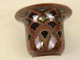 a small brown vase with a green and white design on it