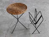 a wicker table and umbrella stand on the concrete floor