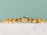 an image of a gold watch sitting on top of a marble counter