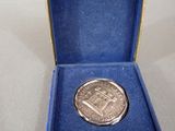 a small silver coin in a blue box on a table