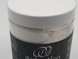 a jar of sea salt sitting on a white surface