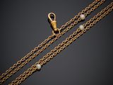 a gold chain with pearls and a clasp