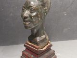 statue of a man ' s head on a wooden base