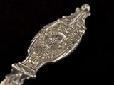 a silver spoon that is sitting on a black surface