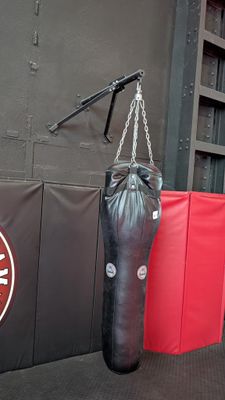 a man standing next to a punching bag in a gym