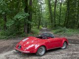 a red car parked on a dirt road in the woods