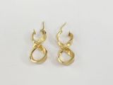 a pair of gold earrings on a white surface