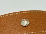 the brown leather belt has a diamond in the center of it