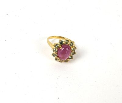 gros plan d'une bague en pierre rose sur une surface blanche