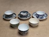 several cups and saucers sitting on top of a wooden table