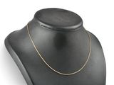 a black mannequin with a gold chain on a white background