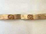 a close up of a gold bracelet on a white napkin