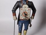 figurine représentant un homme coiffé d'un chapeau et tenant une horloge
