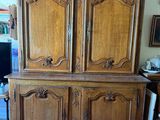 une photo d'une armoire en bois dans une pièce où se trouve un tapis au sol