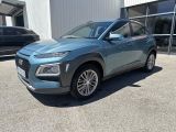 a blue 2020 hyundai kona parked in front of a building