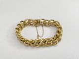a close up of a gold chain bracelet on a white surface