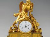 une image représentant une horloge en or surmontée d'un ange