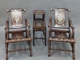 three wooden chairs with carvings on them sitting next to each other