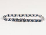 un gros plan sur un bracelet « tennis » orné de pierres bleues