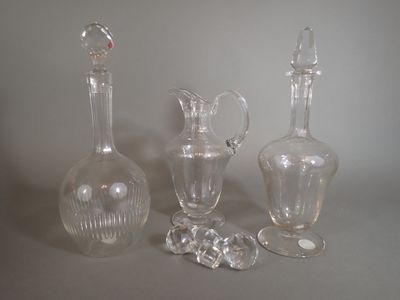three glass vases and a glass bottle on a table