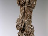 bronze statue of a woman holding a bird on top of a pedestal