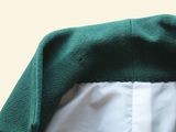 a close up of a green jacket with a white shirt underneath it