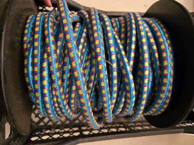 une personne tenant une bobine sur laquelle est enroulée une corde