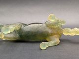 a glass frog figurine sitting on a table